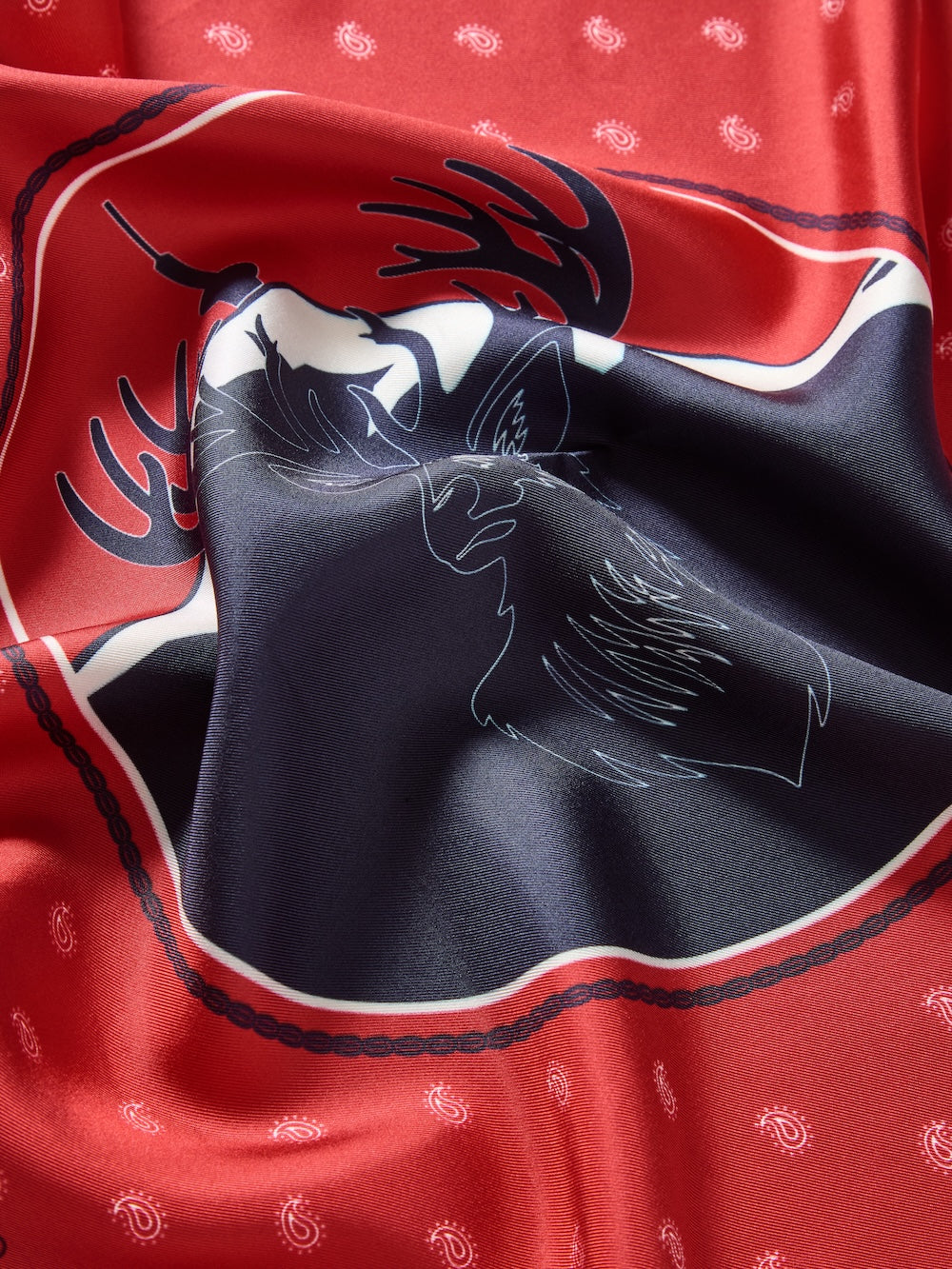 We Norwegians | FW25 | Western silk scarf_Red | Printed with paisley patterns and a center stag motif | Photograph shows the details of the fabric and print